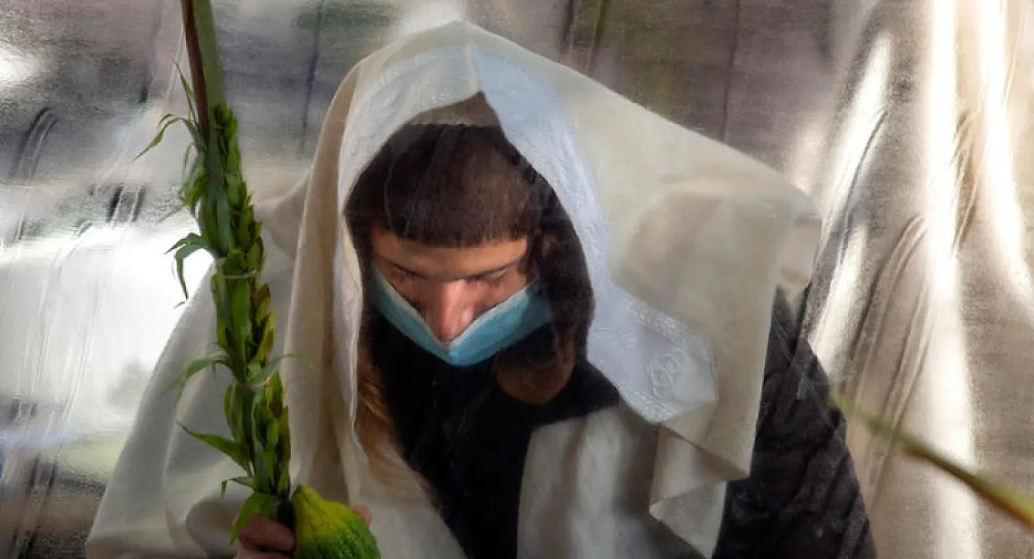 أحد اليهود الأرثوذكس المتشددين (الحريديم) يؤدي صلاته إبان الحظر أمس (أ.ب)