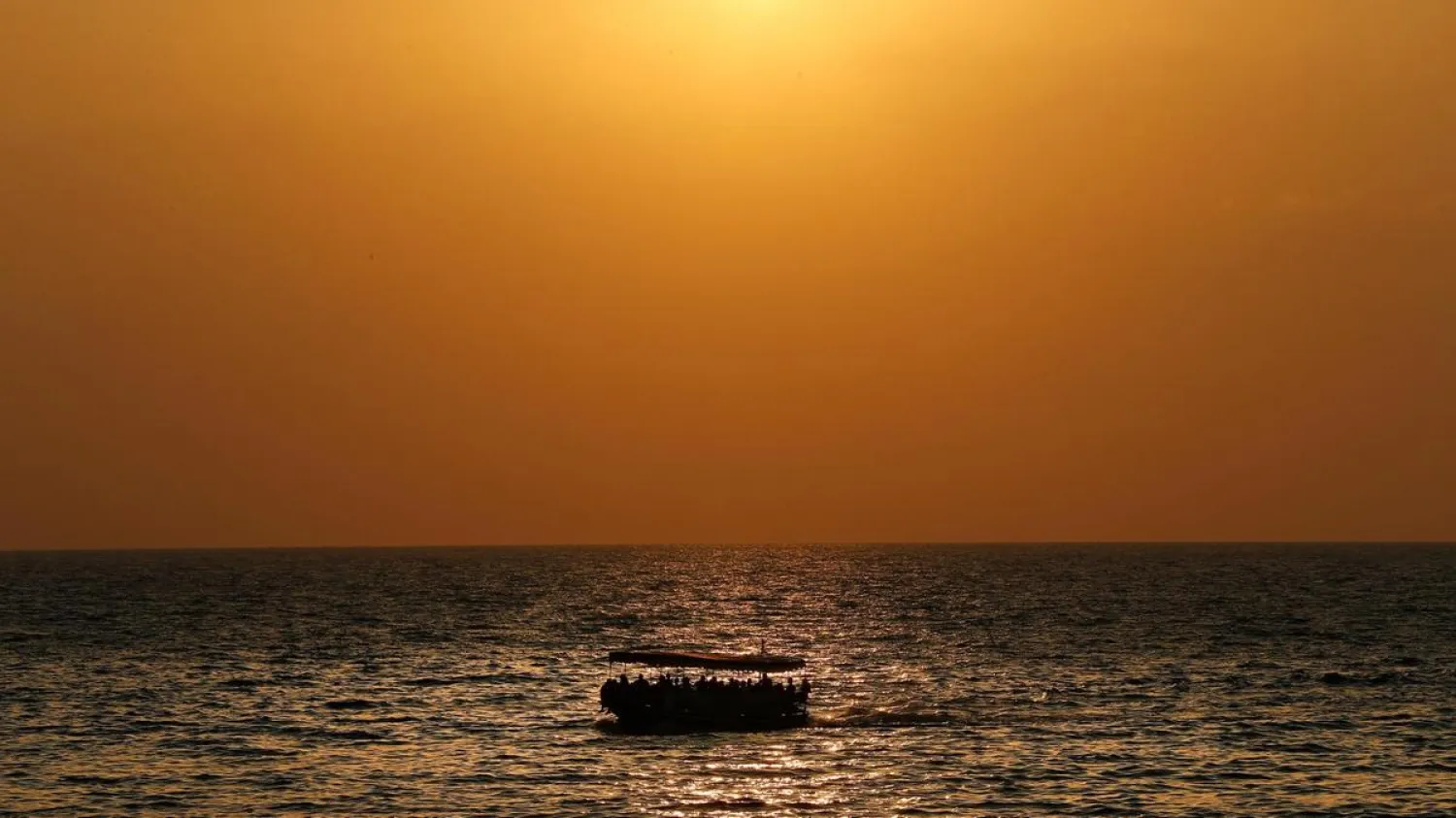 A boat carrying migrants sails off the coast of the northern Lebanese city of Tripoli. (AP)
