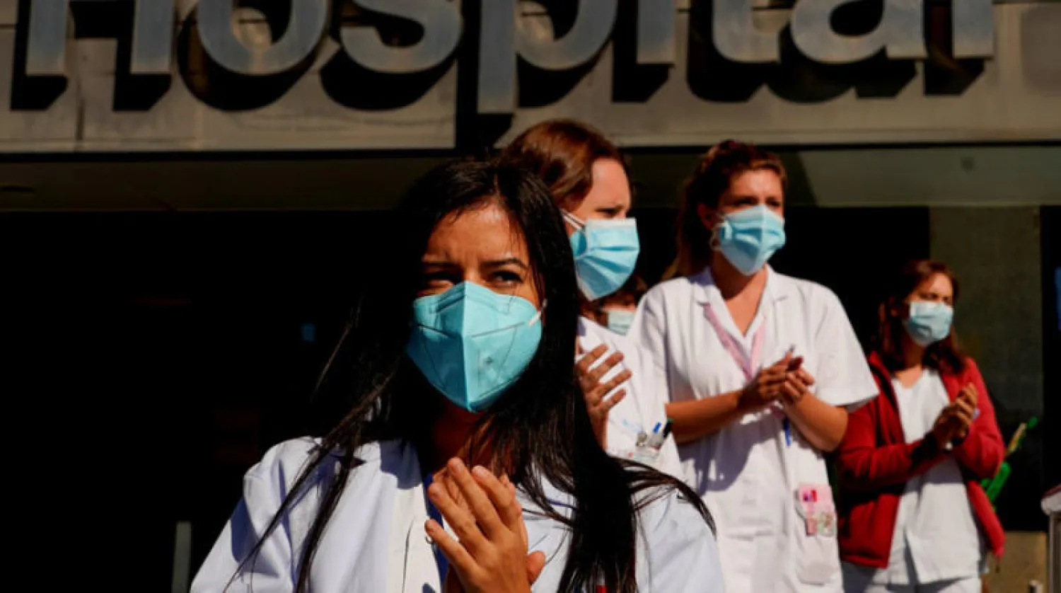أفراد من طاقم طبي بمستشفى في مدريد التي شددت القيود للحد من انتشار «كورونا» (رويترز)