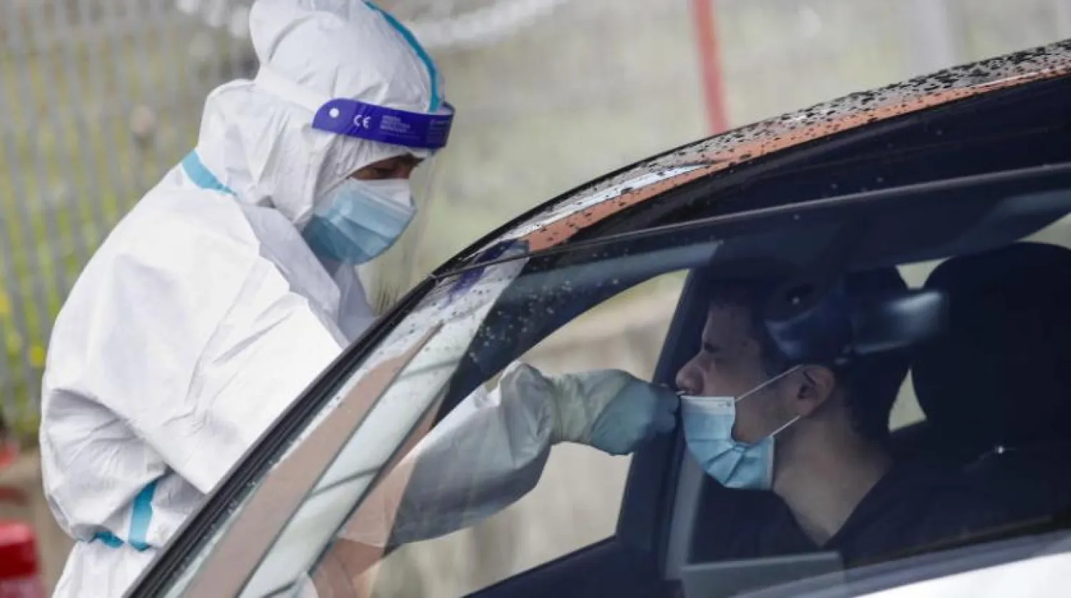 Roma’da bir vatandaşa aracının içinde koronavirüs testi yapılıyor (EPA)