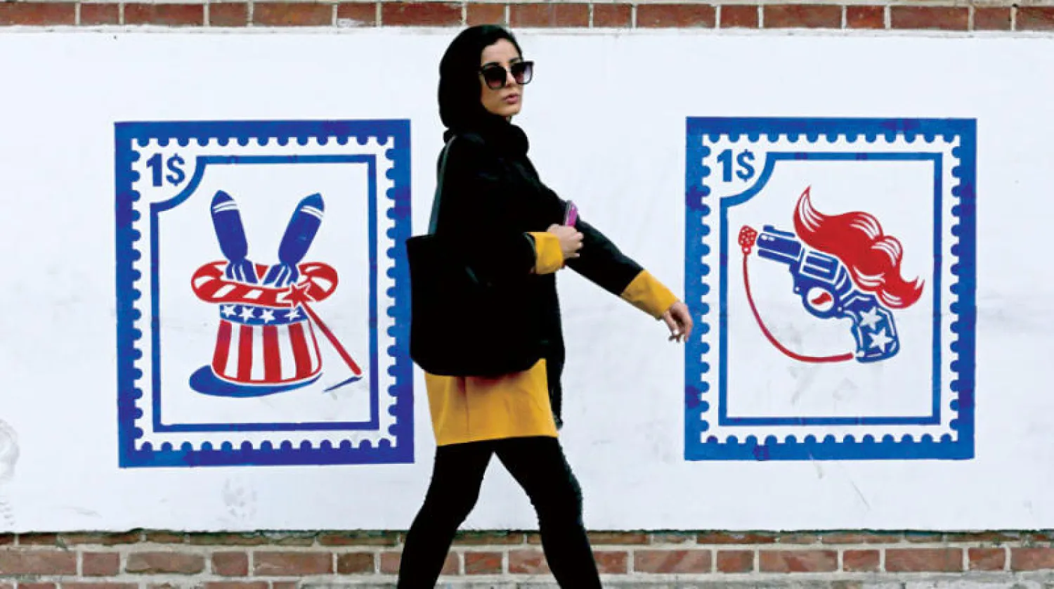 إيرانية تمر من أمام جدارية على حائط السفارة الأميركية السابقة في طهران الشهر الماضي (أ.ف.ب)