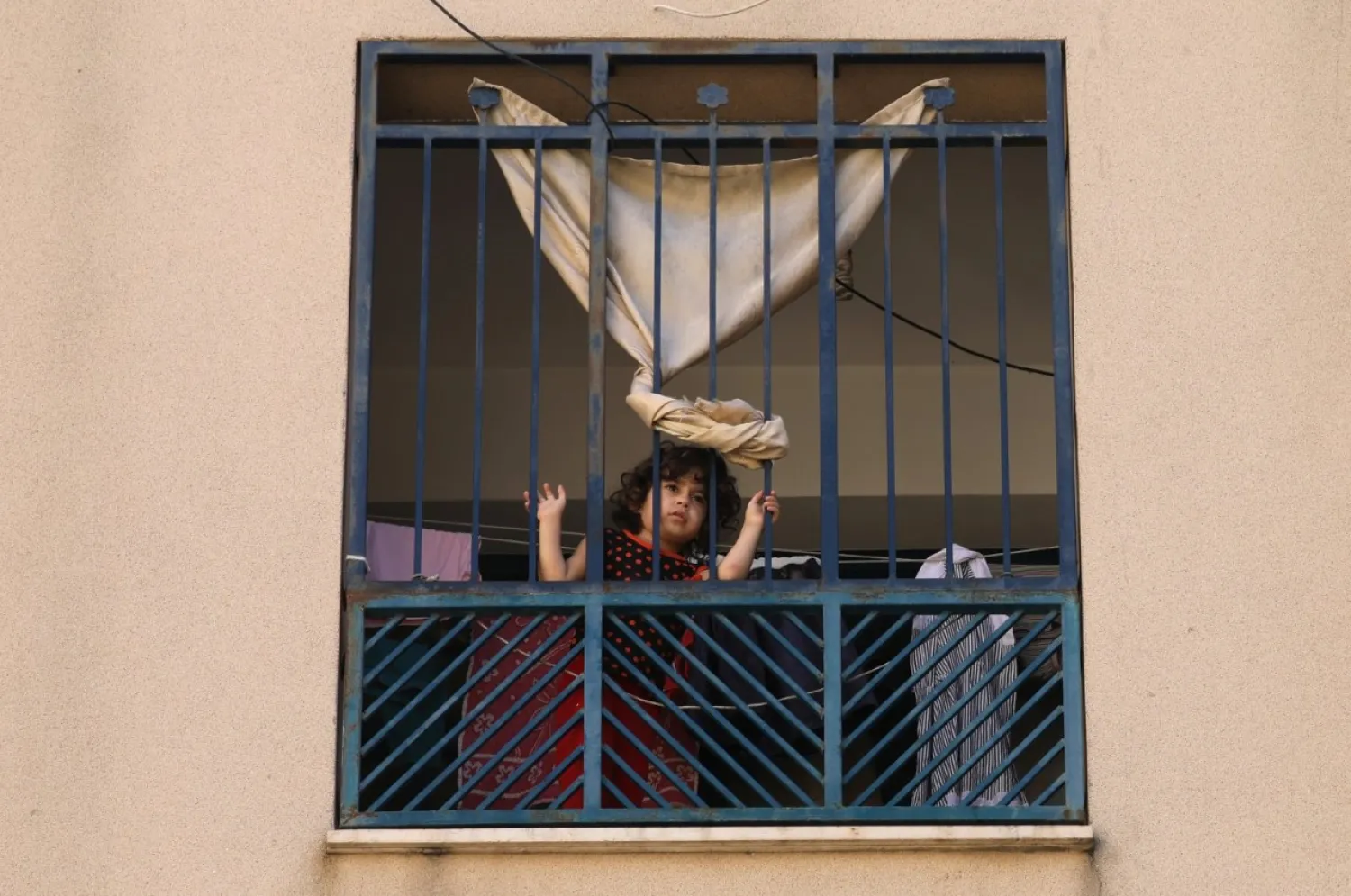 A Palestinian girl looks out the window of her family apartment at the Sheikh Zayed housing estate in the northern Gaza Strip, Aug. 24, 2020. (Reuters Photo)