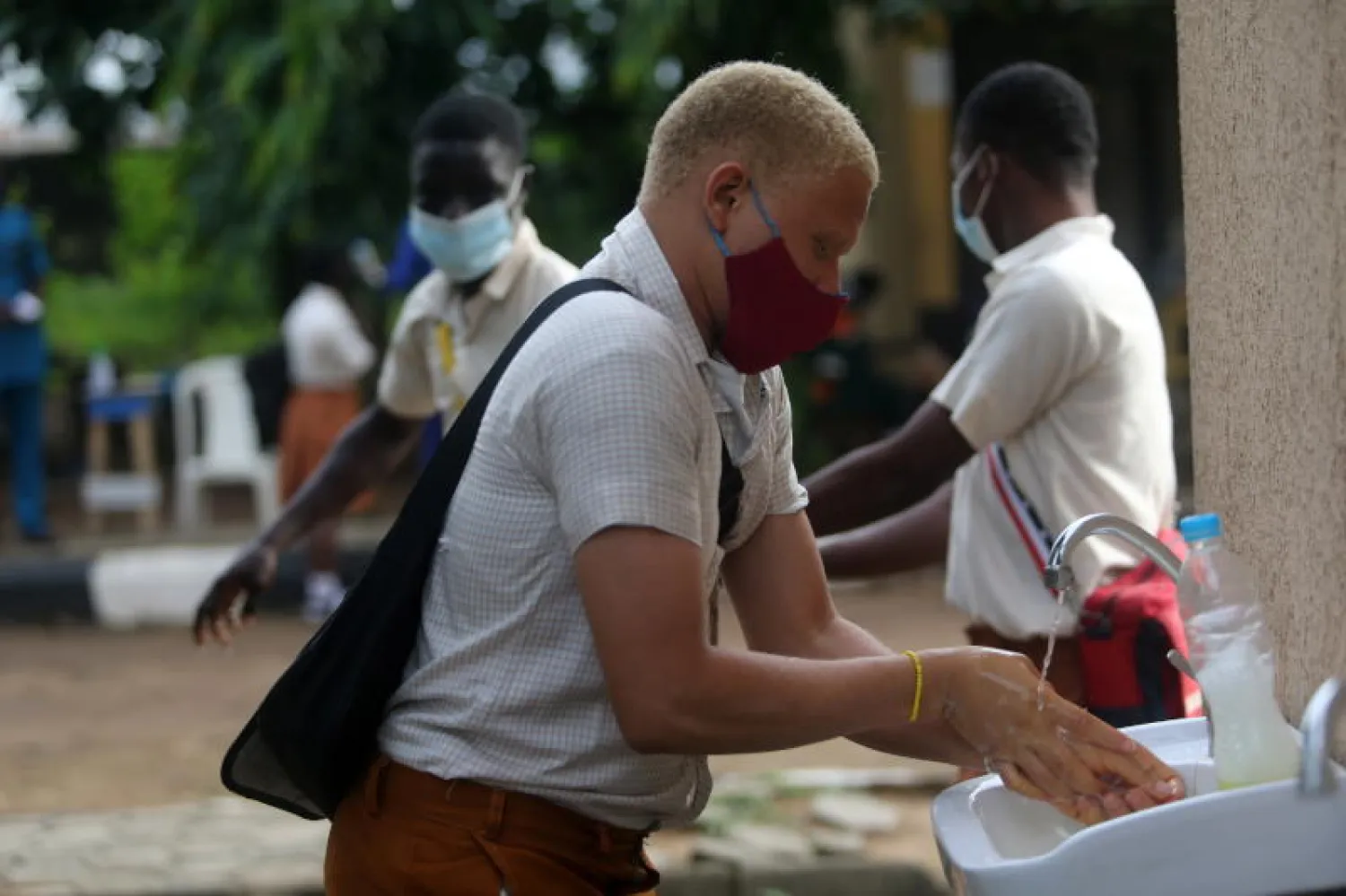 طالب يقوم بغسل يديه في احد مدارس لاغوس بنيجيريا (إ.ب.أ)