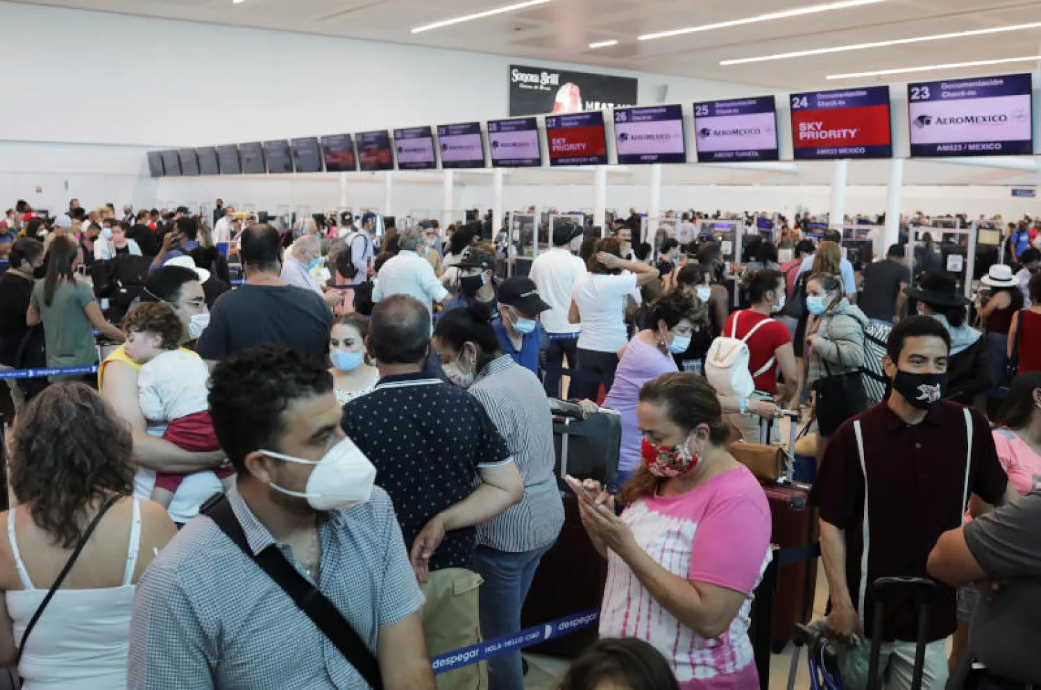 مسافرون يضعون الأقنعة الواقية خوفاً من «كورونا» في مطار بالمكسيك (رويترز)