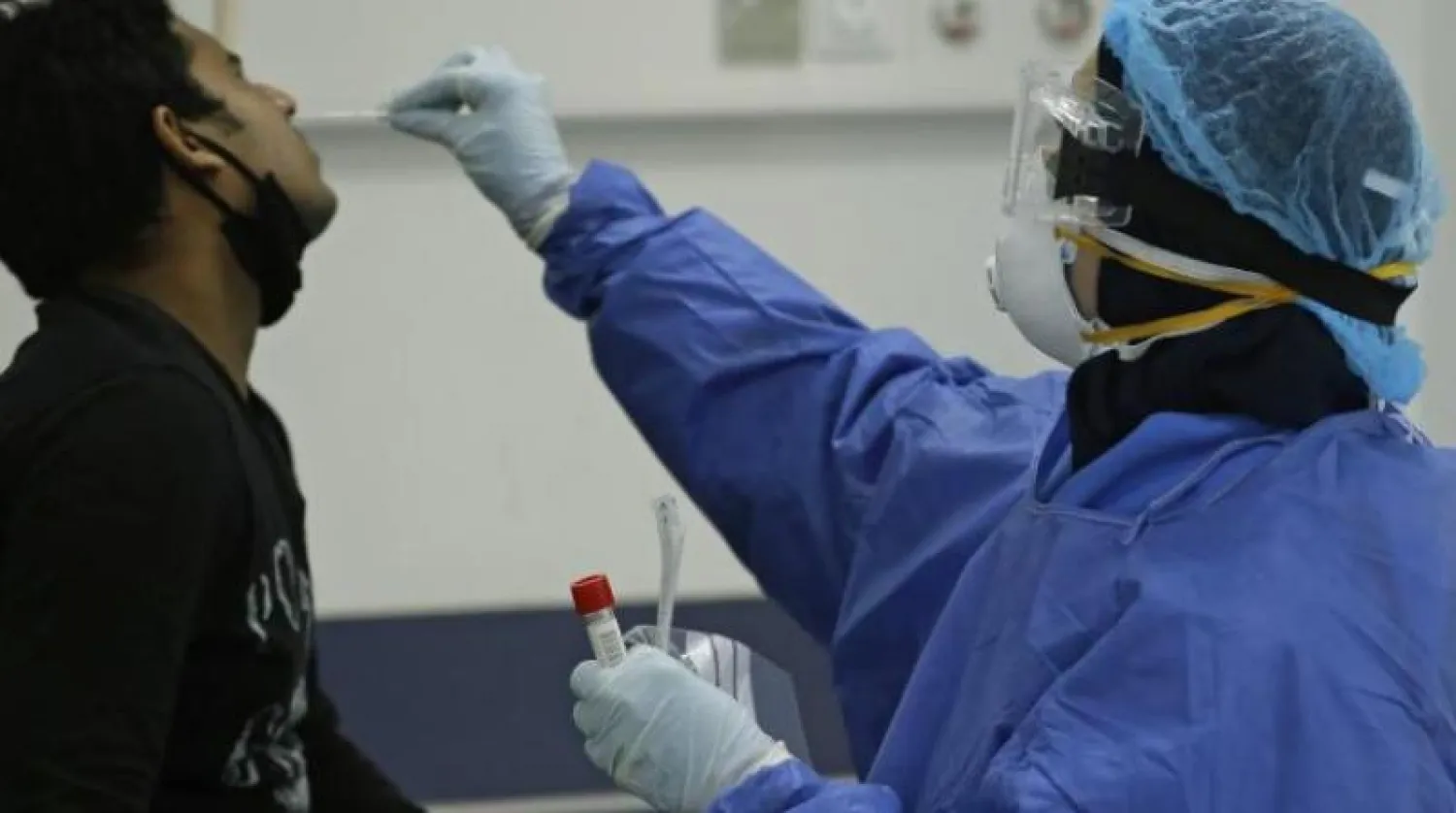 ممرضة تأخذ عينة من مريض يشتبه في إصابته بفيروس كورونا بمستشفى رفيق الحريري الحكومي في بيروت (أ.ف.ب)