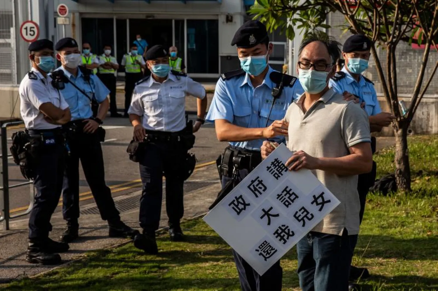 ضابط شرطة من هونغ كونغ يمسك بأحد النشطاء خلال احتجاجات (أ.ف.ب)