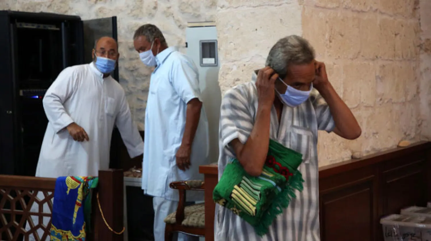 مصلون ليبيون يرتدون كمامات في أحد مساجد تاجوراء بجنوب شرقي طرابلس أول من أمس (أ.ف.ب)