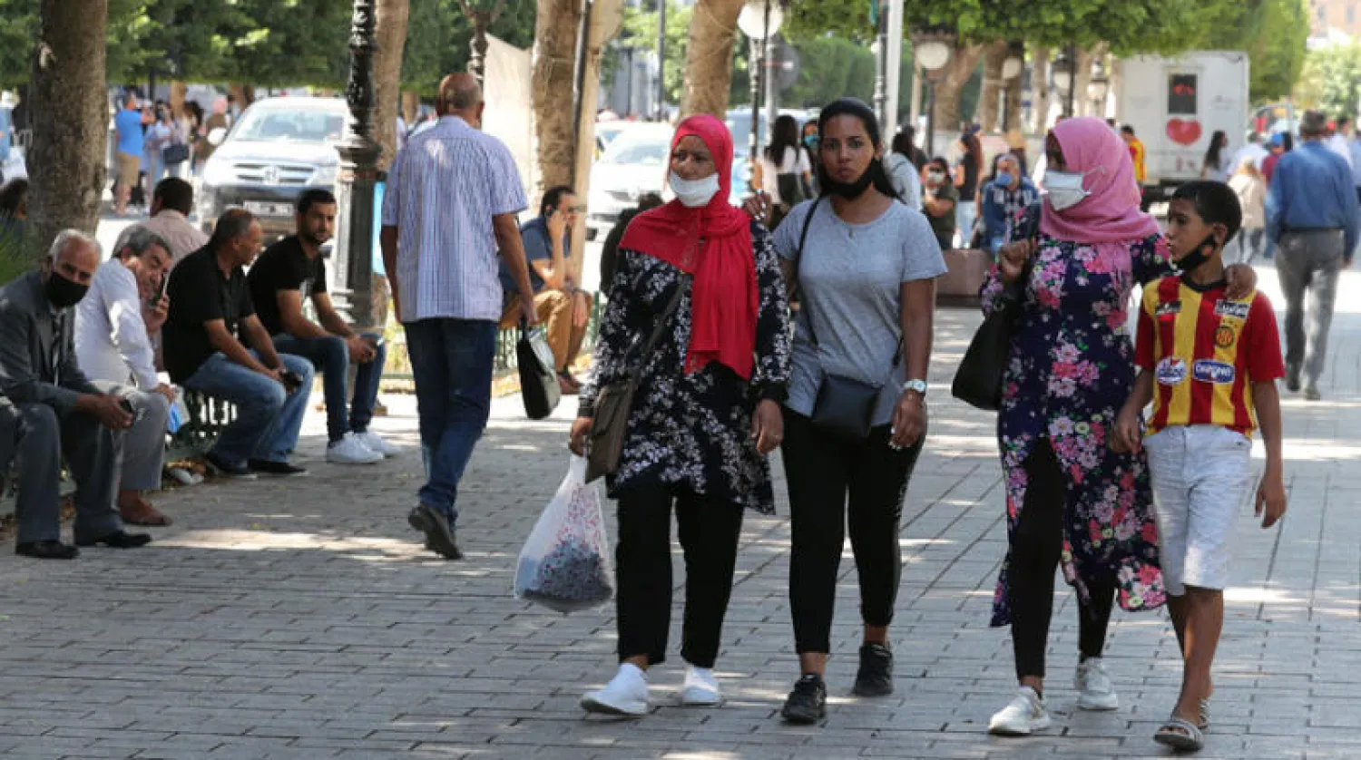 مواطنون يرتدون كمامات للوقاية من الفيروس في العاصمة التونسية أول من أمس (إ.ب.أ)
