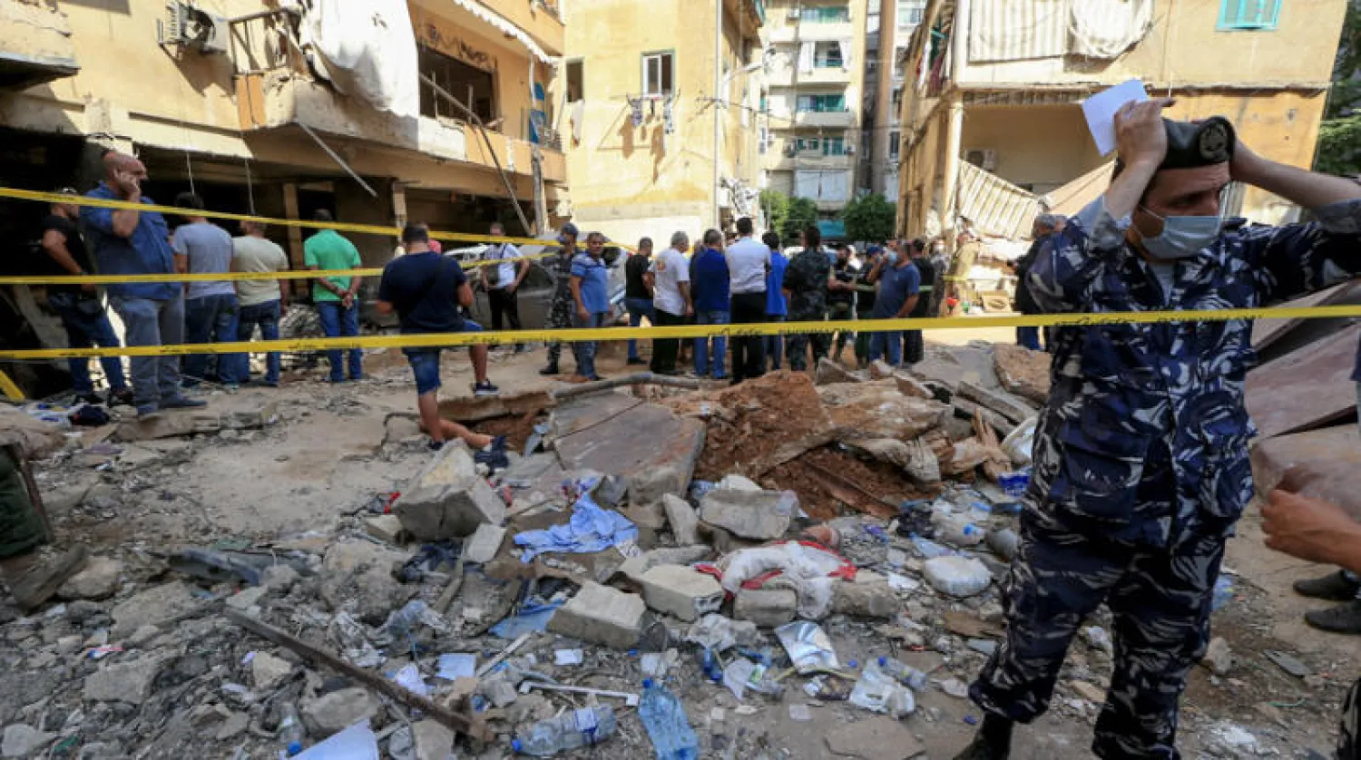 رجال أمن ومواطنون في موقع الانفجار في الطريق الجديدة (إ.ب.أ)