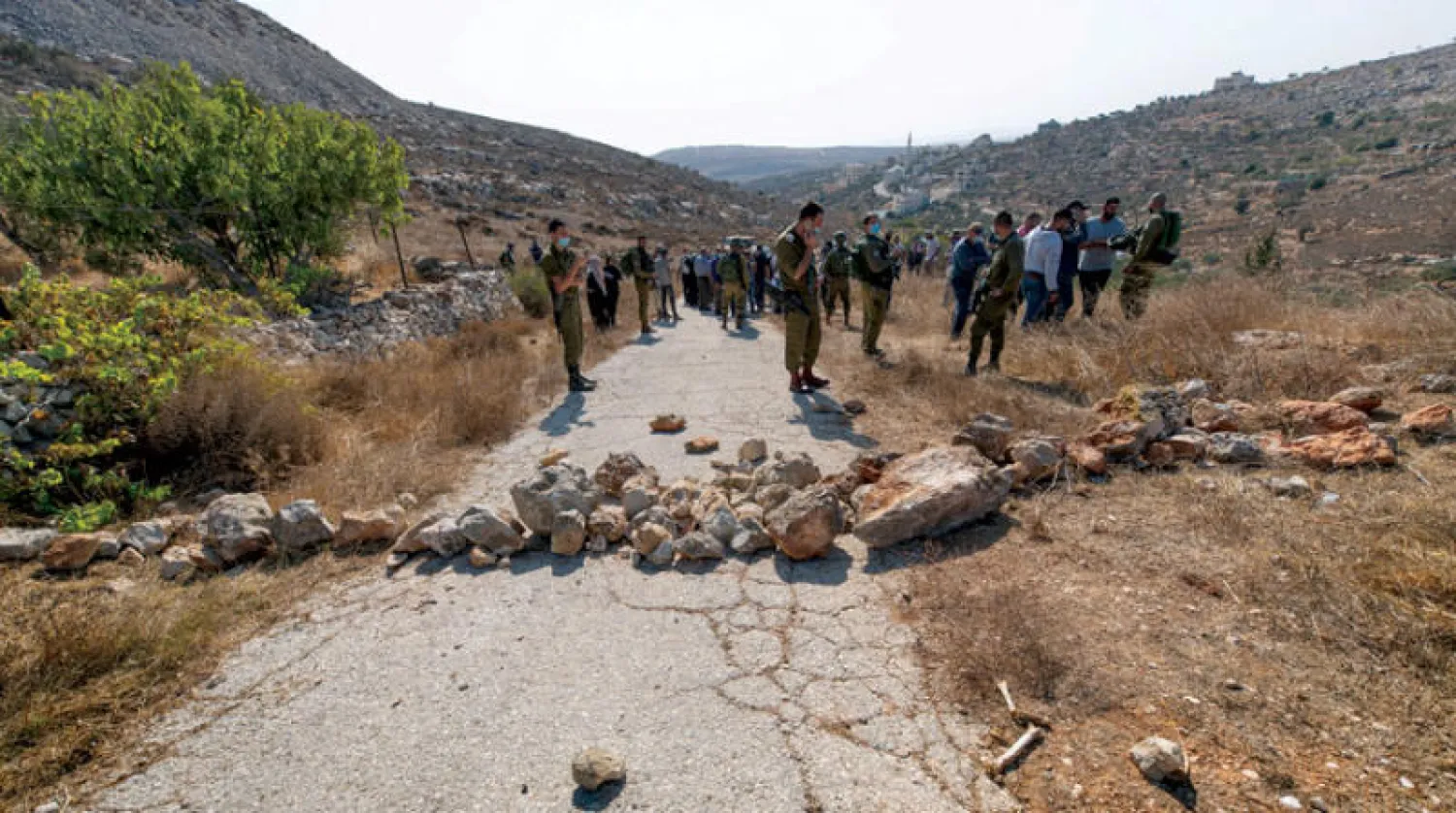إغلاق طريق تقود إلى مزارع الزيتون قرب رام الله لمنع الفلسطينيين من الوصول إلى أشجارهم (أ.ب)