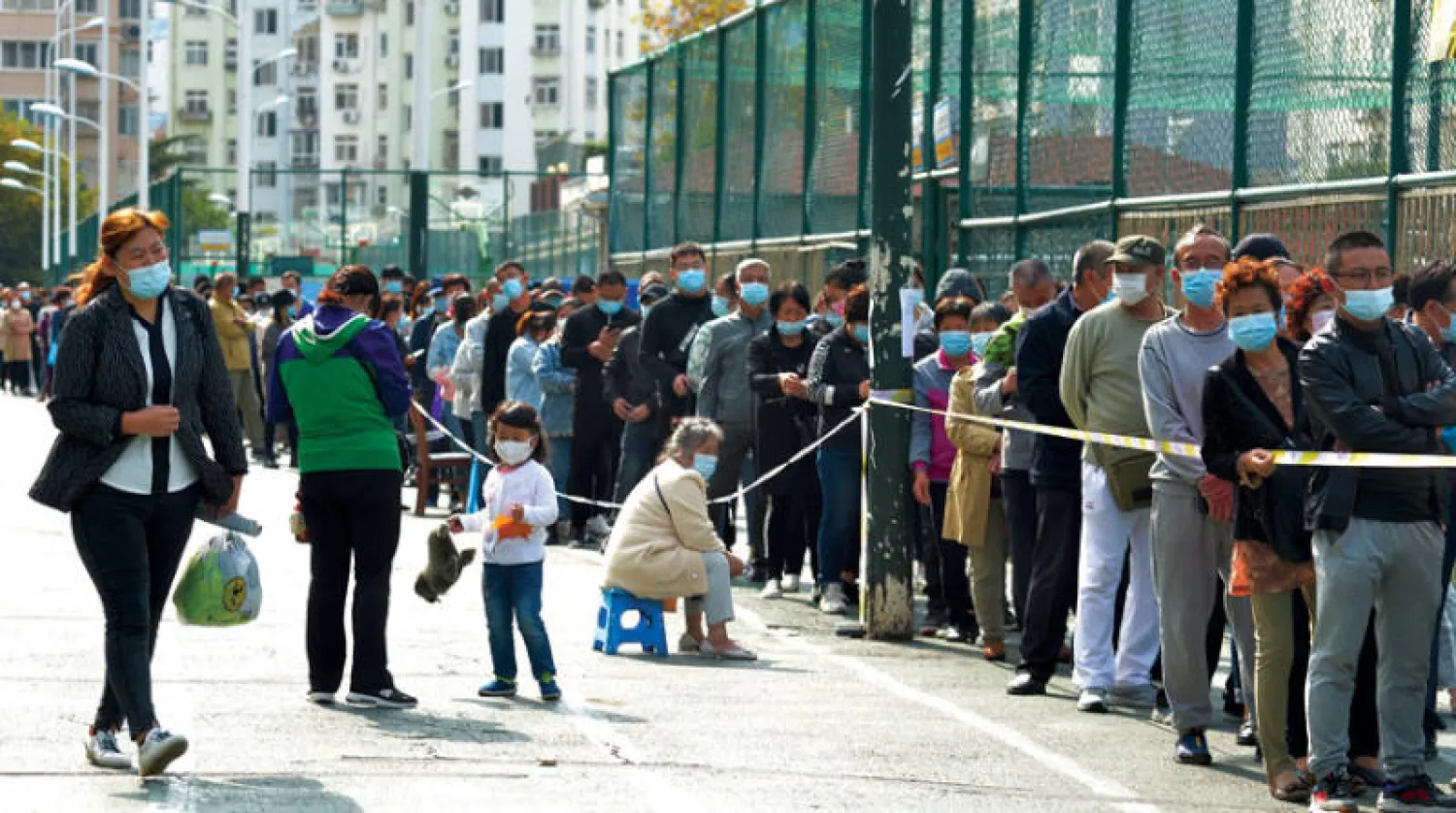 صينيون ينتظرون فحصهم في تشينغداو بعد قرار السلطات أمس فحص جميع سكان المدينة للتأكد من سلامتهم من «كورونا} (أ.ب)