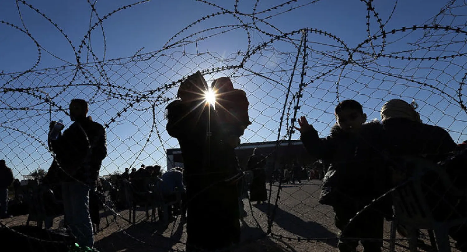 عائلات فلسطينية عند معبر رفح الحدودي مع مصر (رويترز)