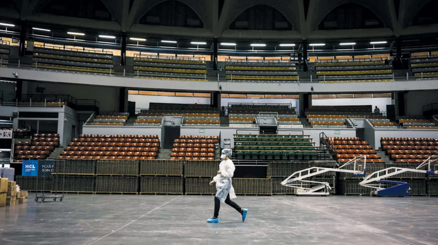 عاملة في القطاع الصحي داخل صالة رياضية كبرى حوّلت إلى مركز لإجراء فحوصات «كوفيد 19» في مدينة ليون الفرنسية أمس (أ.ف.ب)