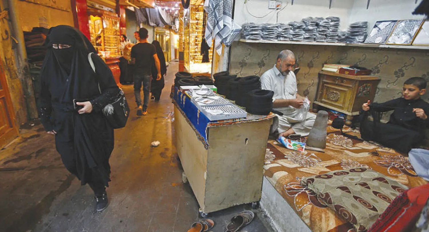 عراقيون في سوق بالنجف أمس (رويترز)