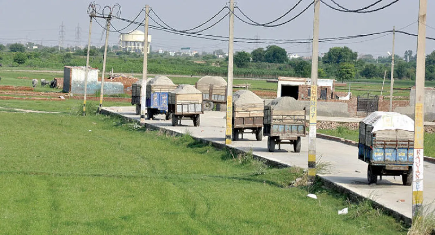 عربات محملة بالرمال في قرية لوني بالقرب من مدينة غازياباد الهندية (غيتي)