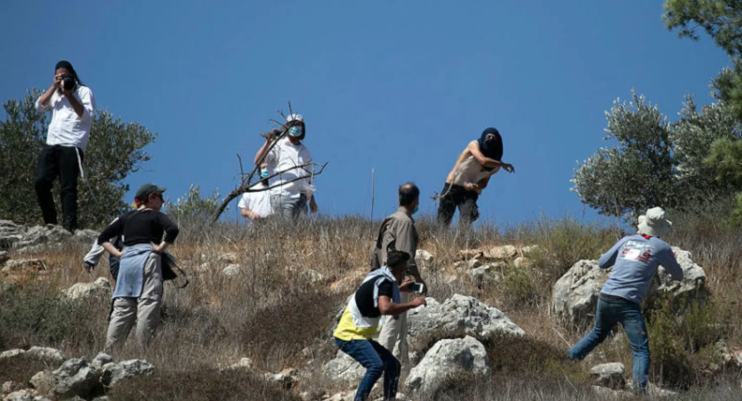 مستوطنون يهاجمون مزارعين في موسم حصاد الزيتون بقرية حوارة بالضفة (أ.ف.ب)