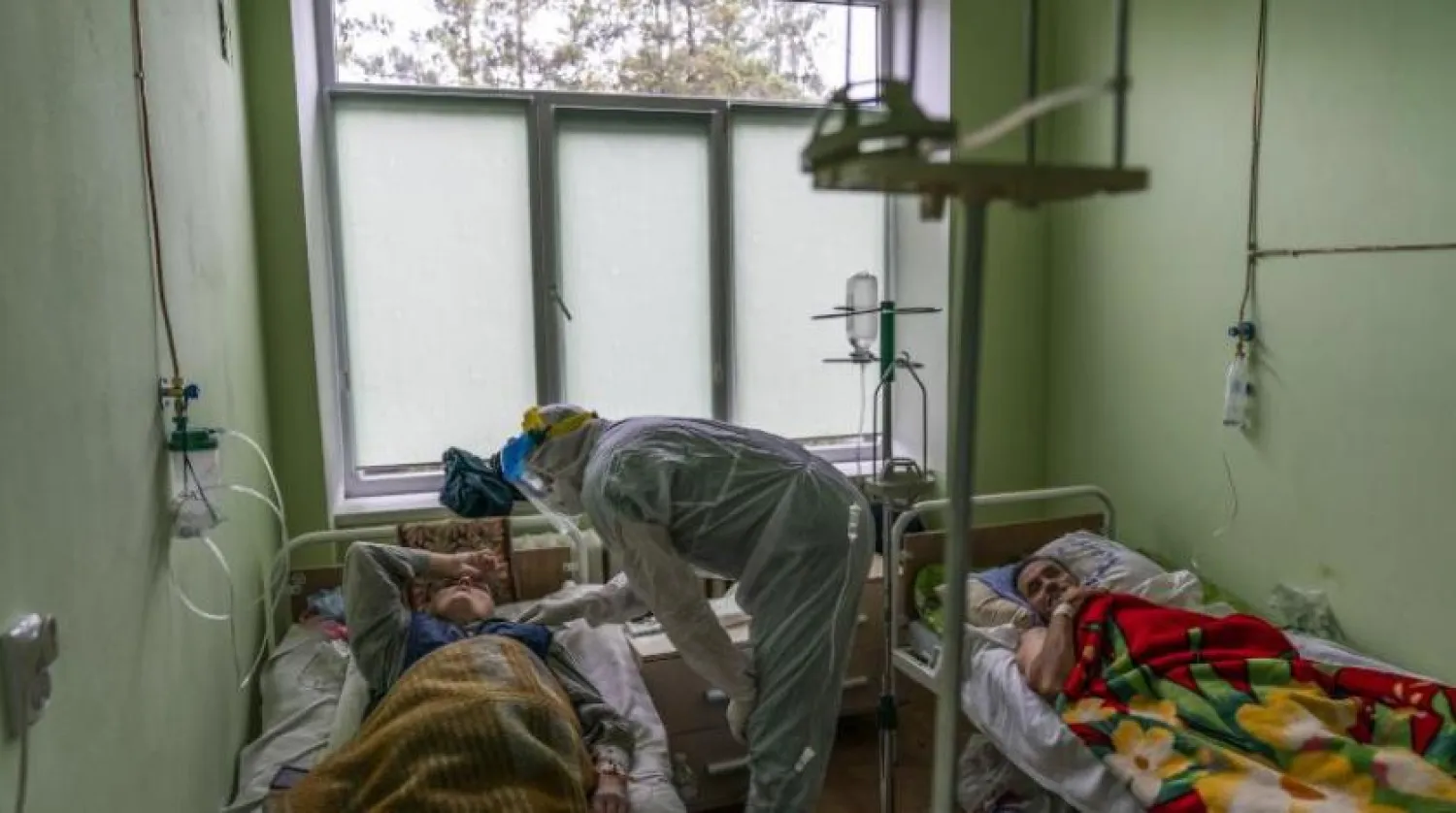 Ukrayna'da bir hastanenin yoğun bakım ünitesinde bir doktor koronalı bir hasta ile görüşüyor (AP)