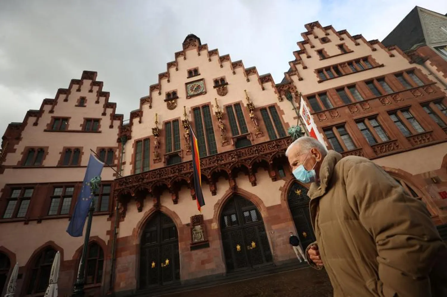 A man wearing a face mask walks in front of the Roemer townhall, as the spread of the coronavirus disease (COVID-19) continues, in Frankfurt, Germany, October 12, 2020. REUTERS/Kai Pfaffenbach