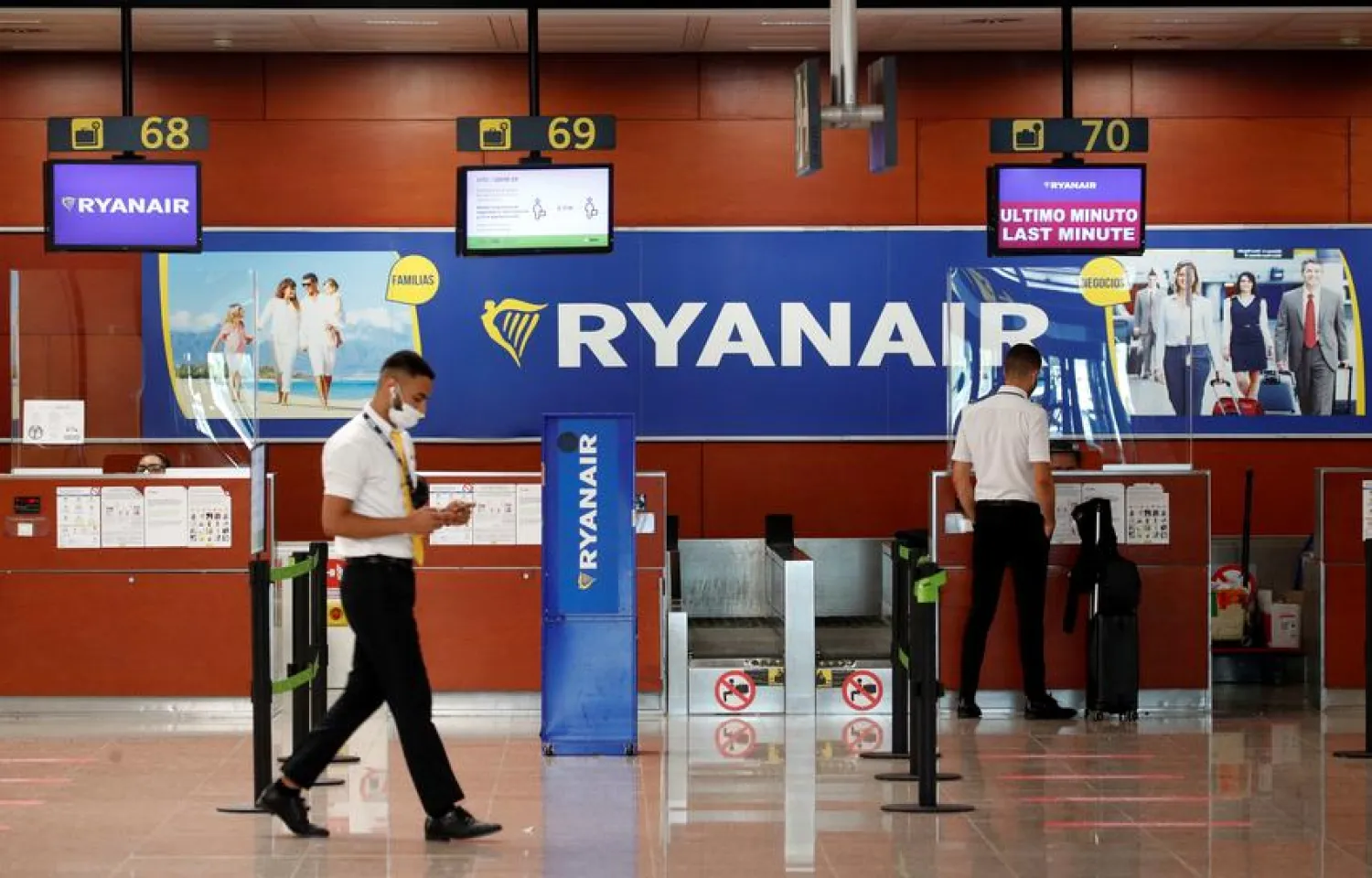 A man stands at a Ryanair check-in desk at Josep Tarradellas Barcelona-El Prat airport, amid the spread of the coronavirus disease (COVID-19), in Barcelona, Spain, July 26, 2020. REUTERS/Albert Gea/File Photo