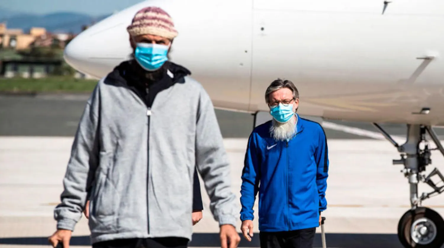 الكاهن الإيطالي بيير لويجي ماكالي (يمين) ومواطنه تشياشيو ينزلان في مطار شيامبينو بروما الجمعة بعد إطلاق سراح الرهينتين من قبل المتطرفين في مالي إلى جانب عاملة الإغاثة الفرنسية صوفي بترونين (أ.ف.ب)