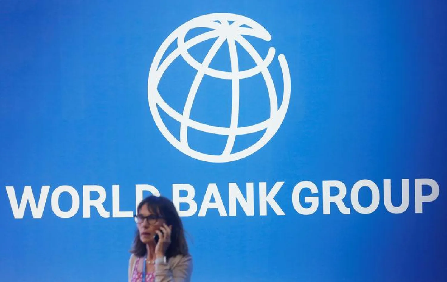 A participant stands near a logo of World Bank at the International Monetary Fund - World Bank Annual Meeting 2018 in Nusa Dua, Bali, Indonesia, October 12, 2018. REUTERS/Johannes P. Christo