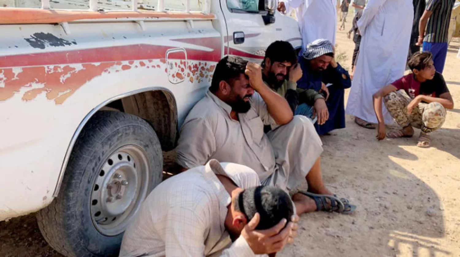 أقارب ضحايا مجزرة الفرحاتية يبكون قبل دفنهم أمس (أ.ف.ب)