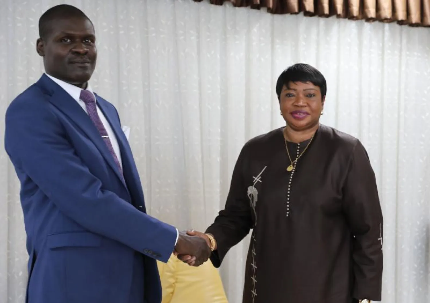 وزير العدل السوداني نصر الدين عبد الباري يصافح المدعية العامة للمحكمة الجنائية الدولية فاتو بنسودا (أ.ف.ب)