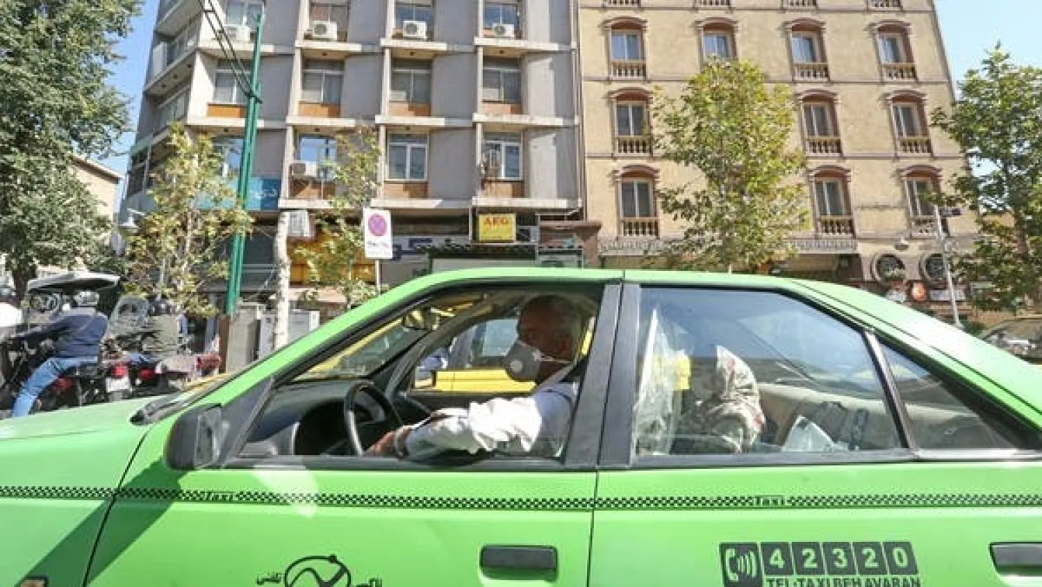 A mask-clad Iranian taxi driver stops at a traffic light in the Islamic republic's capital Tehran. (AFP)
