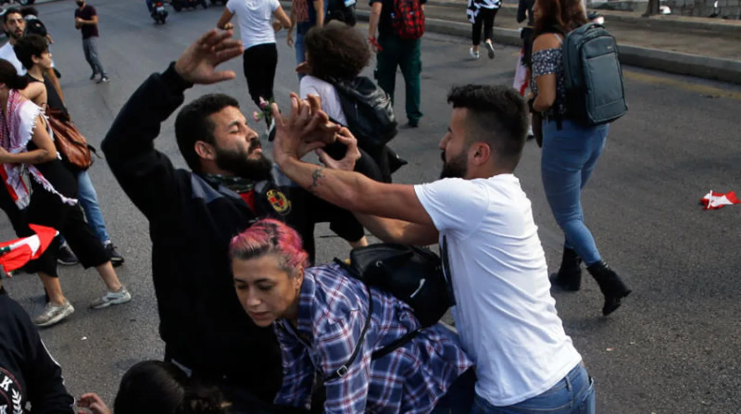 مواجهة بين مؤيد لـ«حزب الله» (يمين) ومشارك في احتجاجات ضد الحكومة اللبنانية في بيروت العام الماضي (أ.ب)