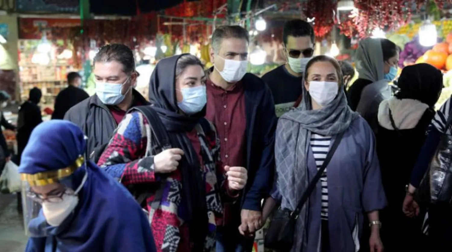 Kovid-19 tedbirleri kapsamında maske takan Tahran Çarşısı'ndaki İranlılar.  (AP)