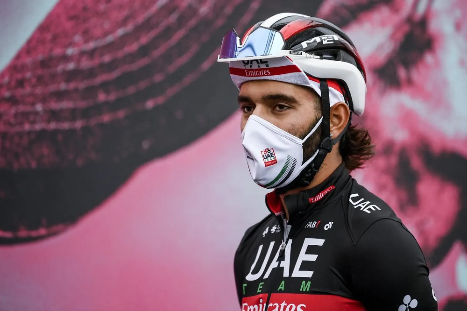 Cyclist Fernando Gaviria wears a face mask to curb the spread of COVID-19 as he attends the 13th stage of the Giro d'Italia cycling race, from Cervia to Monselice, Italy, Oct. 16, 2020. (AP)