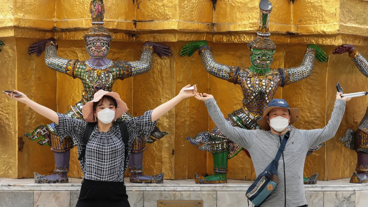 Tourists wear protective masks while posing for a photo at the Grand Palace amid coronavirus fears in Bangkok. (AP)