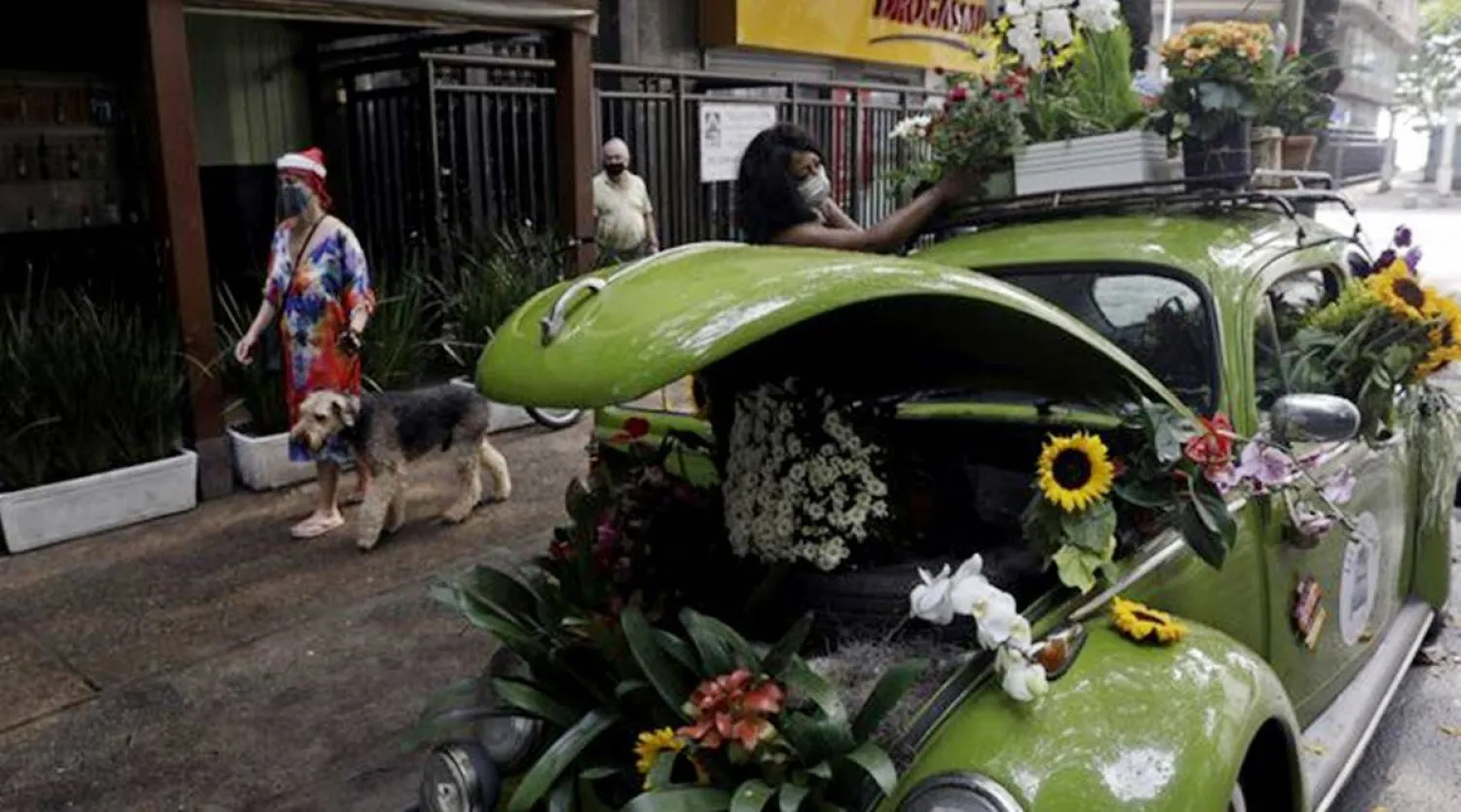 Valcineia Machado, also known as Roberta, organizes her flowers on her car which she transformed to a mobile flower shop. (Photo: Reuters)