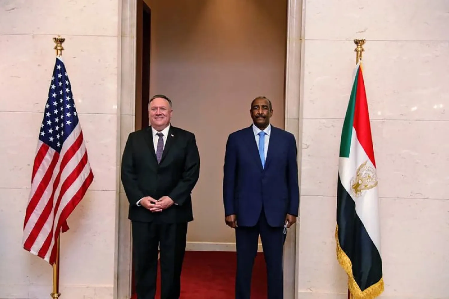 FILE - In this Aug. 25, 2020 file photo, US Secretary of State Mike Pompeo stands with Sudanese Gen. Abdel-Fattah Burhan, the head of the ruling sovereign council, in Khartoum, Sudan (Sudanese Cabinet via AP, File)