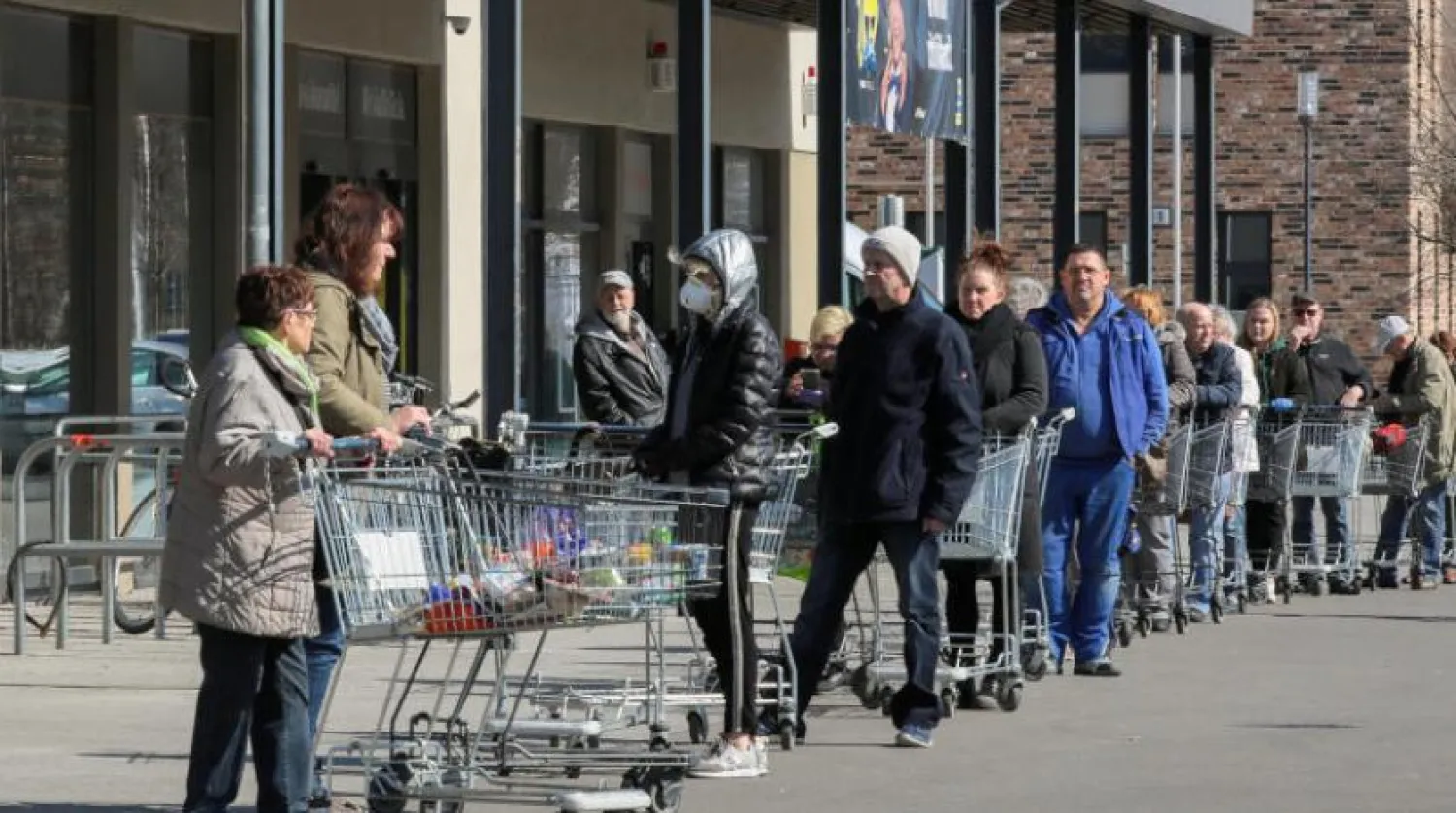 Sırayla mağazaya girmek için başkalarının alışverişi bitirmesini bekleyen müşteriler (Reuters)
