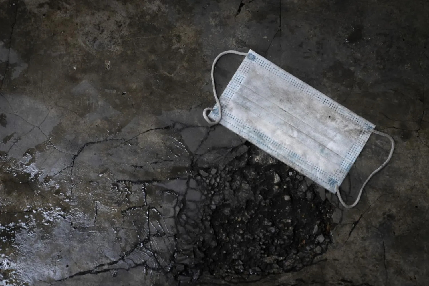 A face mask is seen on a floor as health ministry staff collect samples for coronavirus testing from residents at an urban area in Bandar Utama, outskirt of Kuala Lumpur, Malaysia Thursday, Oct. 22, 2020. (AP Photo/Vincent Thian)