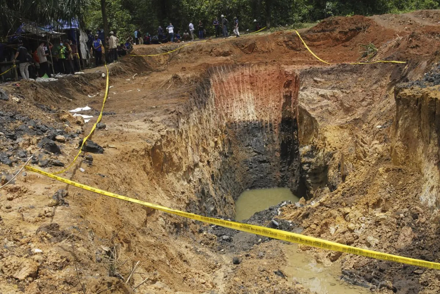 Military personnel inspect the site of a landslide at a coal mine in Muara Enim, South Sumatra, Indonesia, Thursday, Oct. 22, 2020. Intense rains caused a landslide at the mine that killed a number of miners, authorities said Thursday. (Associated Press)