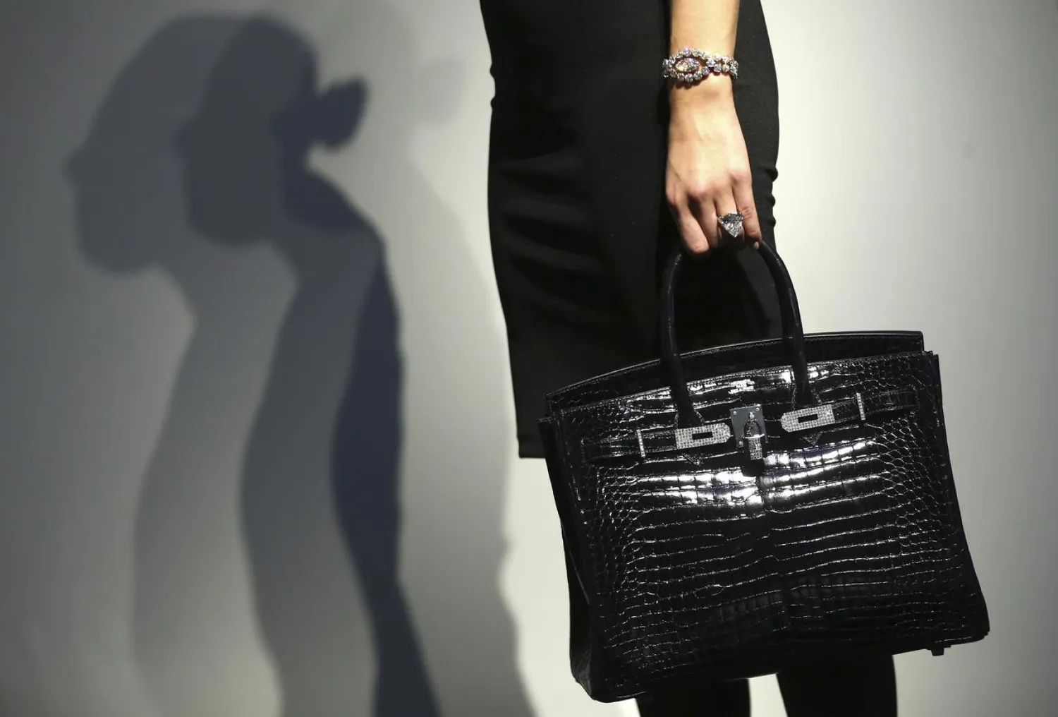 An assistant poses with a Hermes, Exceptional Shiny Bleu Marine Porosus Crocodile Diamond Birkin handbag, a Star of Sierra Leone 968.9 carat diamond ring and a 7.13 carat diamond Cartier bracelet, during a sale preview at Christie's auction house in London, Britain October 20, 2016. REUTERS/Neil Hall