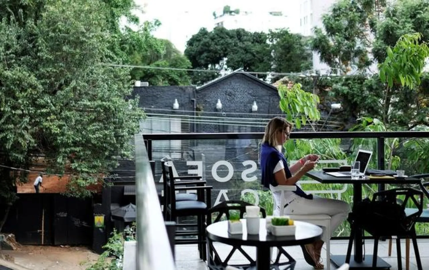 FILE PHOTO: A woman uses her mobile phone and computer at a cafe in Sao Paulo, Brazil October 17, 2017. REUTERS/Nacho Doce