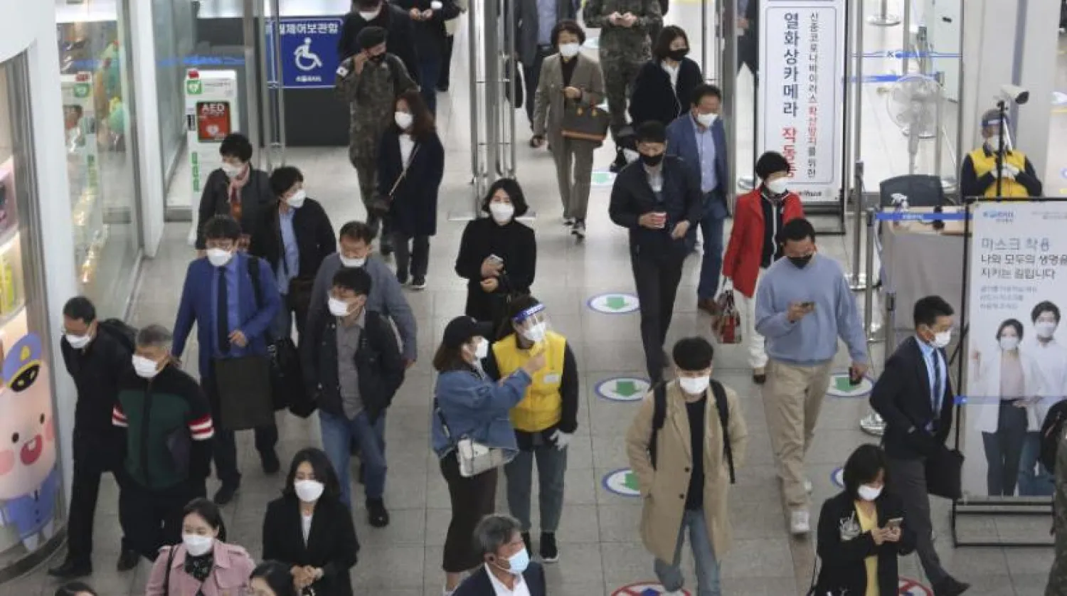 Seul Tren İstasyonunda koruyucu maske takan yolcular (AP)