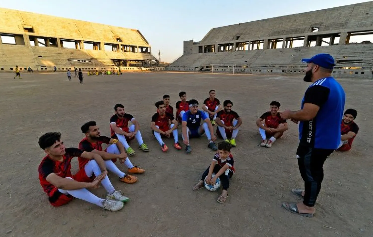Football players train on the dusty pitch of the Al-Idara al-Mahalia stadium in Mosul which was once used by ISIS group fighters as a weapons depot and a launchpad for rocket and mortar attacks | AFP