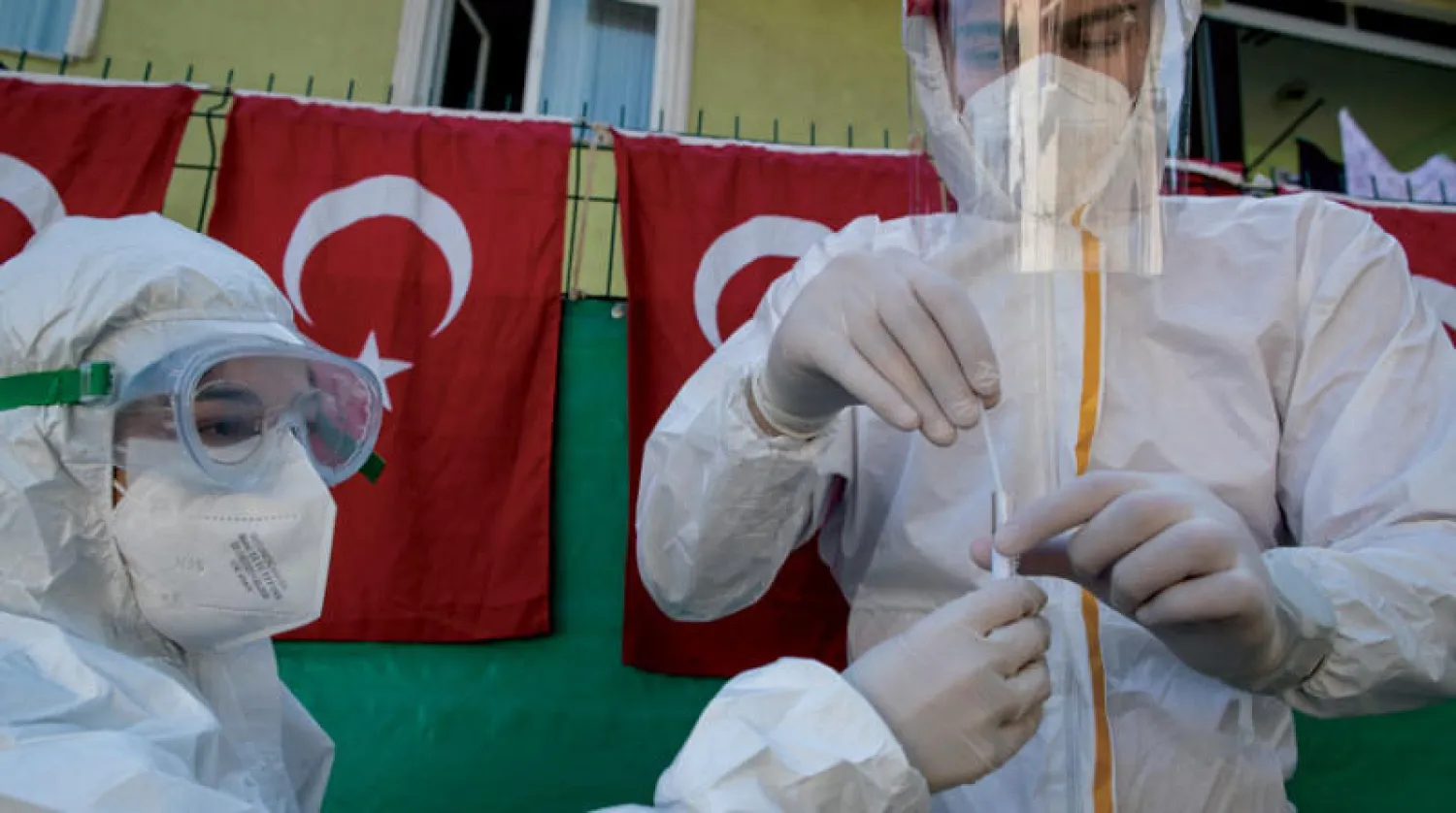 ممرضان يأخذان عينة من مريض في إسطنبول لفحصها (إ.ب.أ)