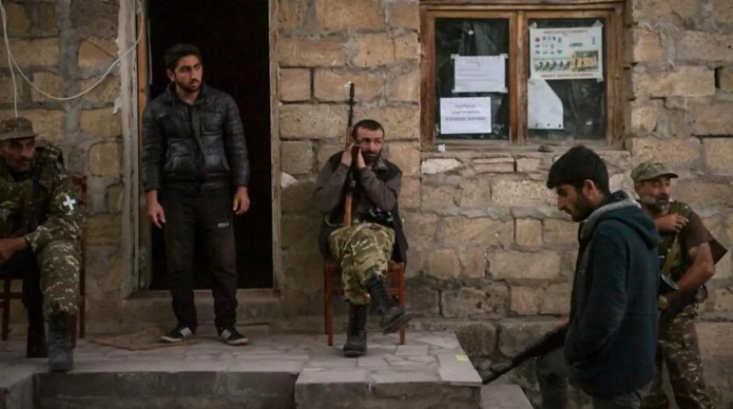 Volunteer fighters stand in a village south-east of Stepanakert on October 23, 2020, during the ongoing fighting between Armenian and Azerbaijani forces over the breakaway region of Nagorno-Karabakh. (Photo by ARIS MESSINIS / AFP)