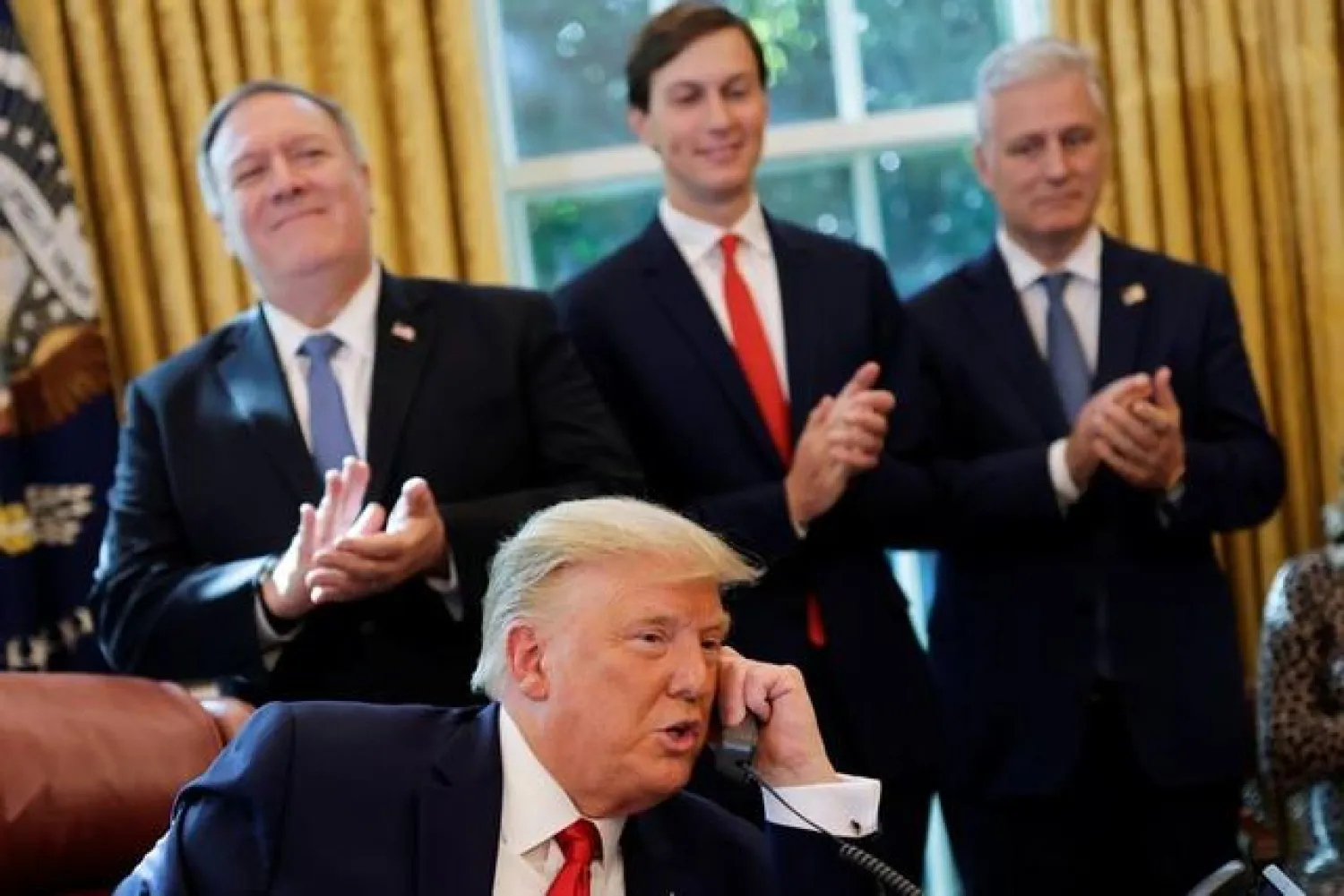  Secretary of State Mike Pompeo and White House senior advisor Jared Kushner applaud as US President Donald Trump is seen on the phone with leaders of Israel and Sudan speaking about the decision to rescind Sudan's designation as a state sponsor of terrorism, in the Oval Office at the White House in Washington, US, October 23, 2020. REUTERS/Carlos Barria

