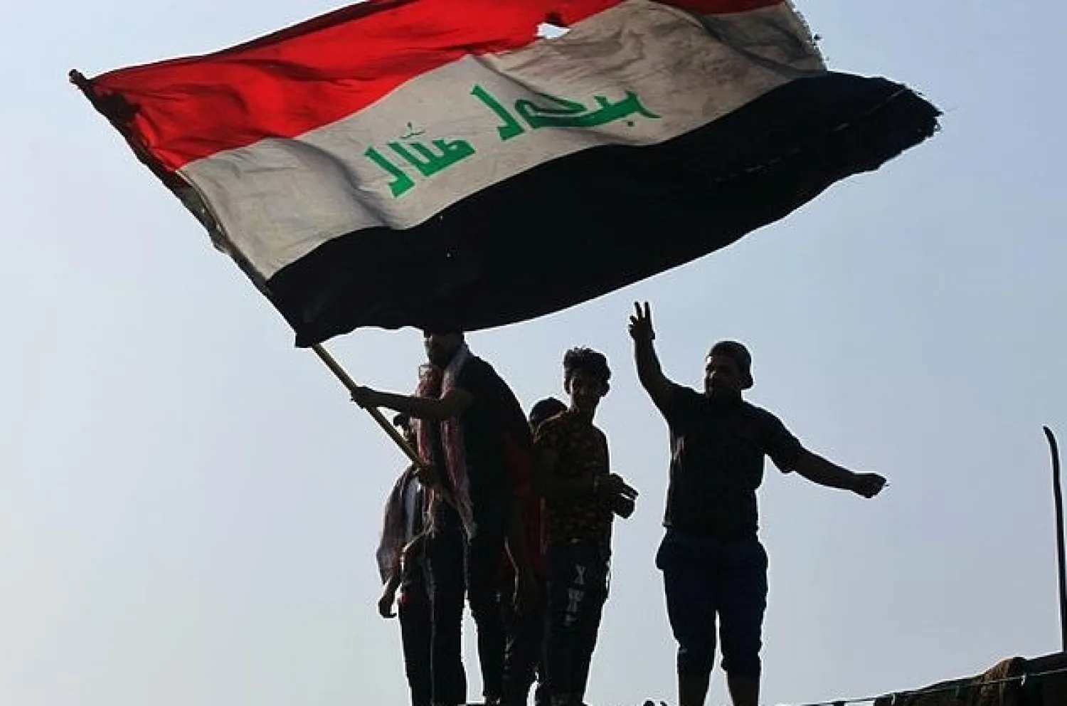 Iraqi demonstrators wave a flag as they gather in Tahrir Square in the center of the capital Baghdad to mark the first anniversary of a movement demanding the ouster of the entire ruling class accused of corruption. AFP

