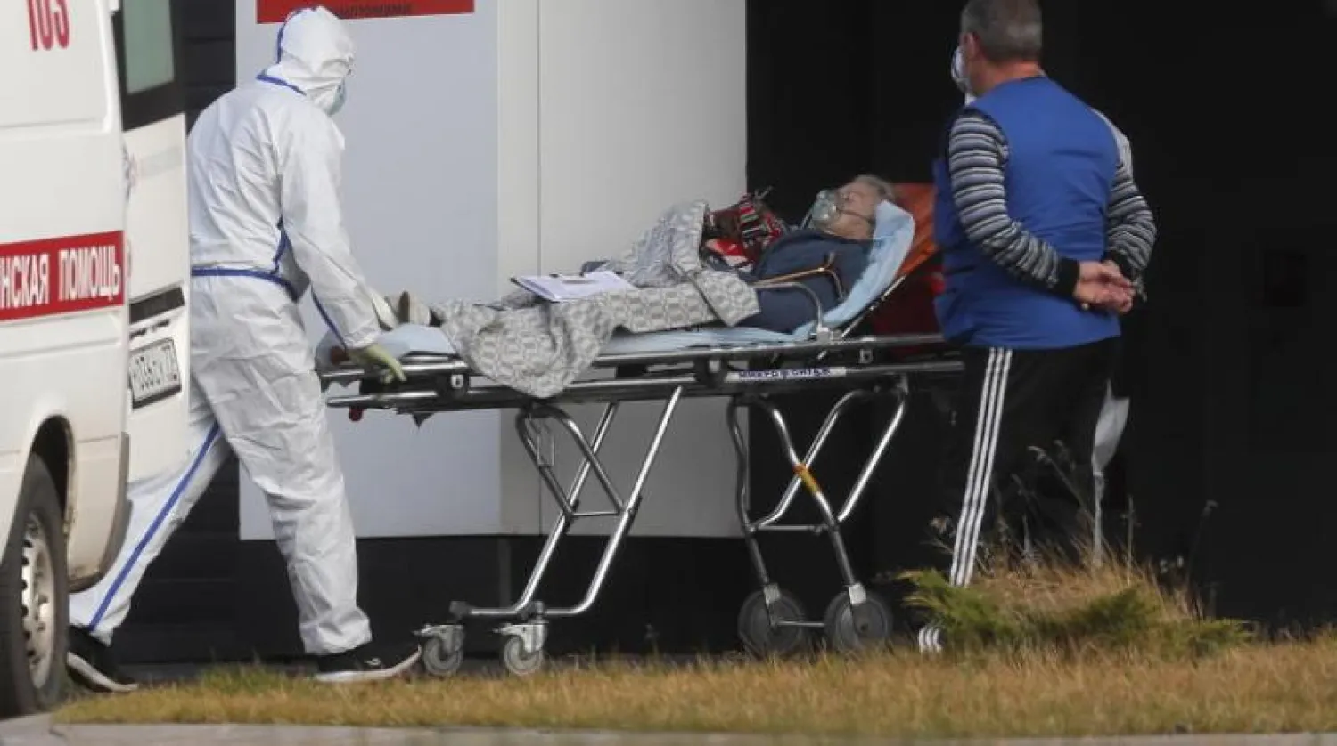 Rusya’nın başkenti Moskova’da Kovid-19’a yakalanan bir hastayı nakleden sağlık ekibi (EPA)