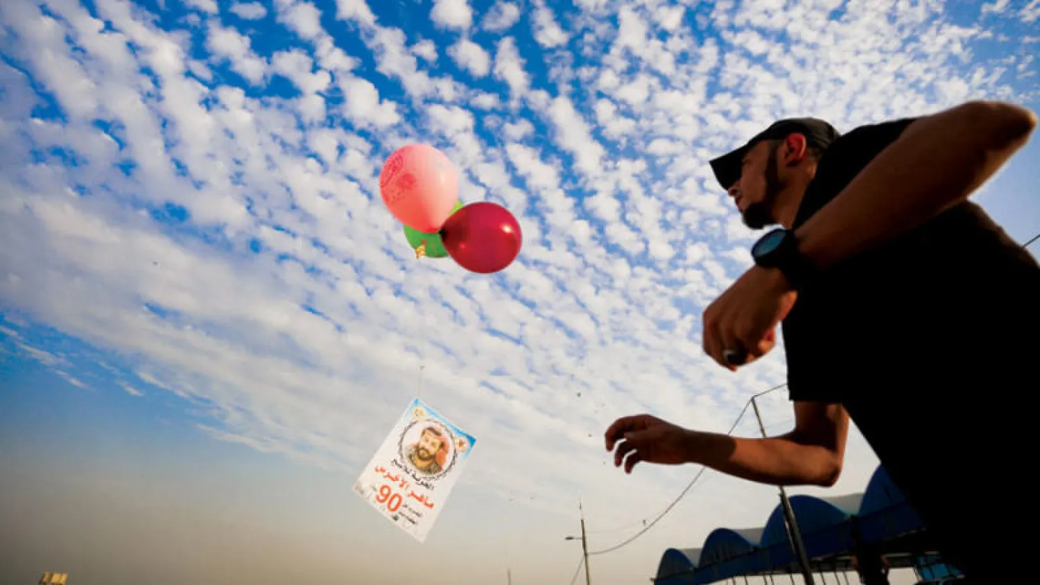 فلسطينيون من غزة يطلقون بالونات ملونة تضامناً مع الأسير ماهر الأخرس (د.ب.أ)