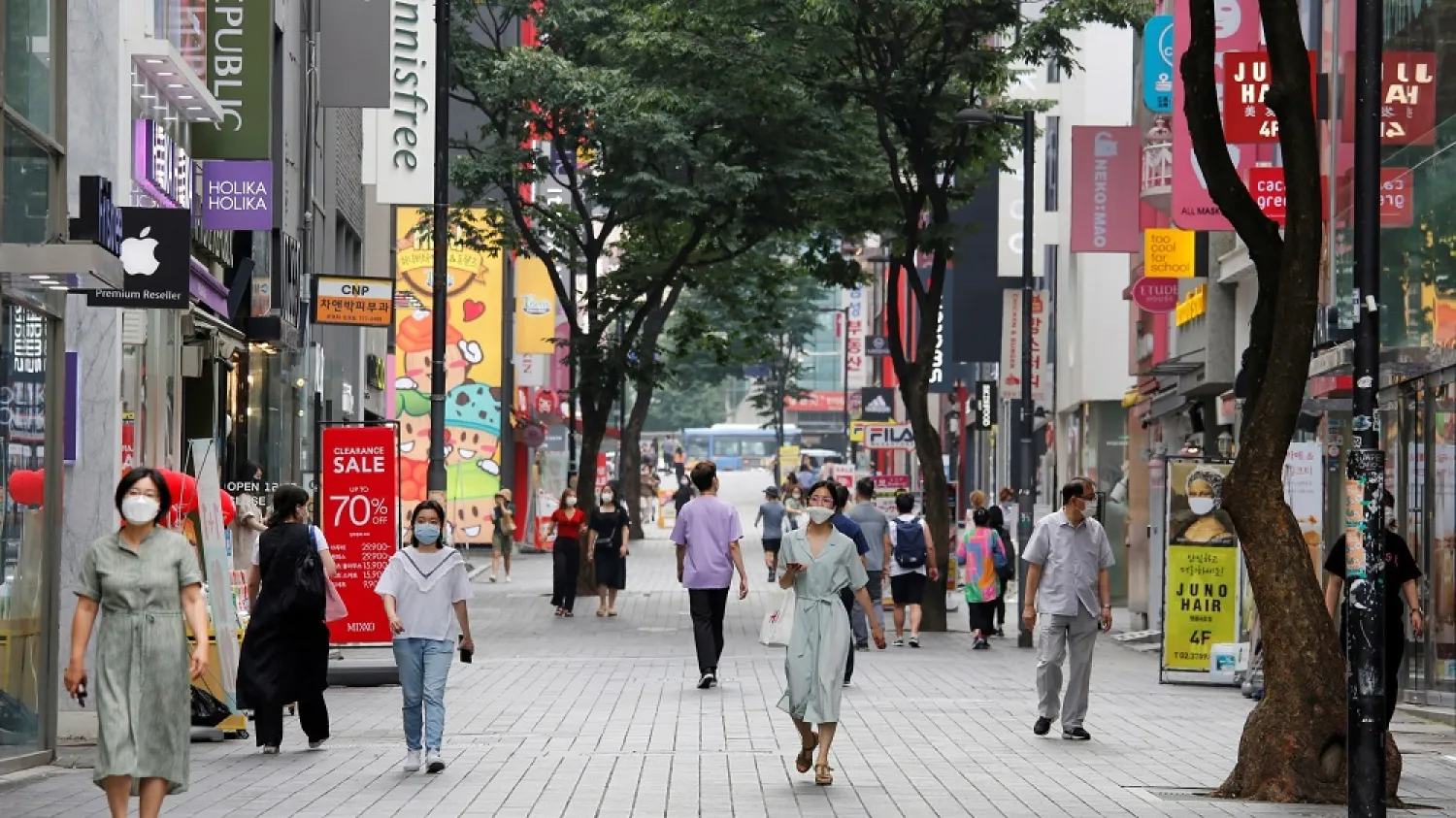 People wearing masks walk at Myeongdong shopping district in Seoul. (Reuters)