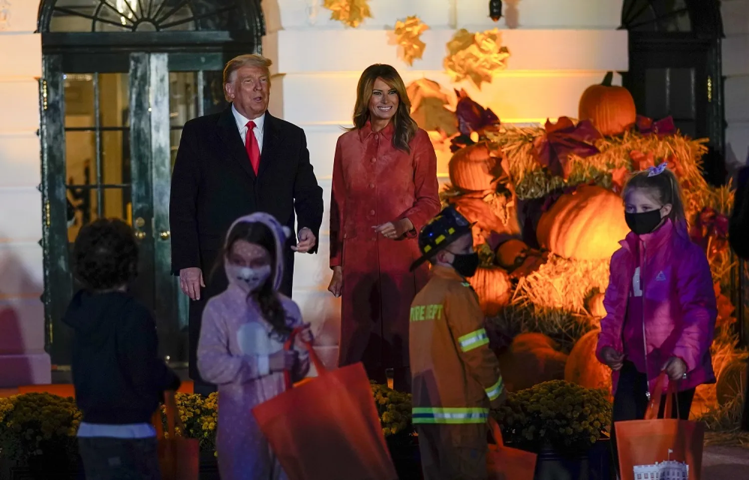 President Donald Trump and first lady Melania Trump greet trick-or-treaters on the South Lawn during a Halloween celebration at the White House, Oct. 25, 2020 in Washington. (AP)