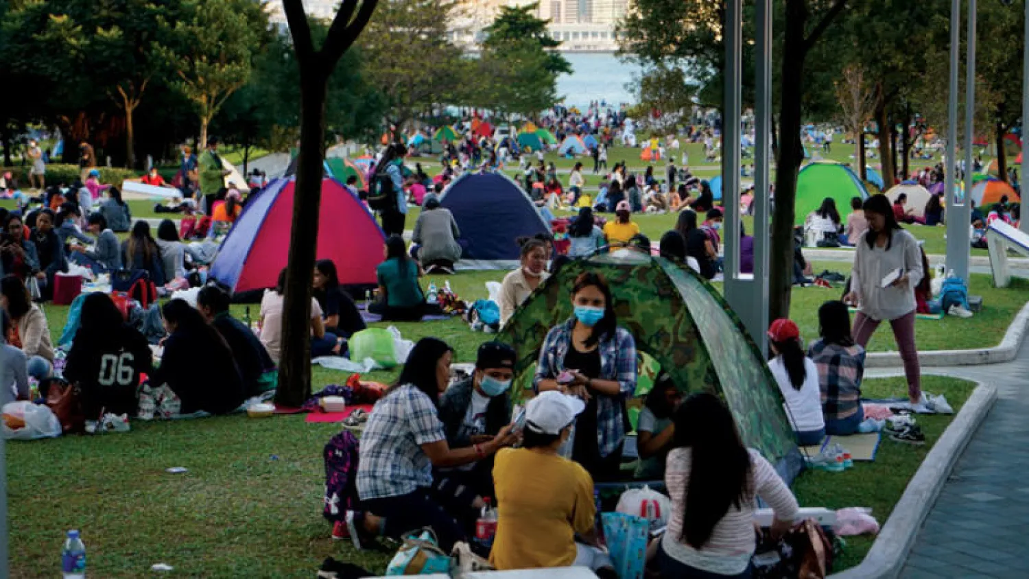 عاملات منزليات من الفلبين وإندونيسيا خلال تجمع في عطلة نهاية الأسبوع بمنطقة فيكتوريا هاربور بهونغ كونغ أمس (أ.ب)